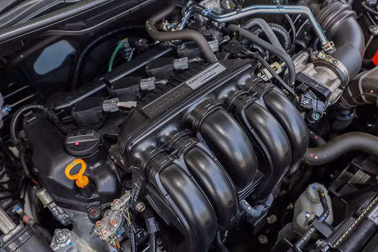 Nằm bên dưới nắp ca-pô của Honda City 2023 là 2 tùy chọn động cơ. Thứ nhất là động cơ xăng 4 xi-lanh, hút khí tự nhiên, dung tích 1.5L, sản sinh công suất tối đa 121 mã lực và mô-men xoắn cực đại 145 Nm. Động cơ này kết hợp với hộp số sàn 6 cấp hoặc hộp số biến thiên vô cấp CVT.