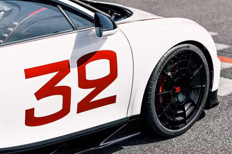 Chiếc Chiron Pur Sport Grand Prix thứ 2 lần này do một khách hàng ở Singapore đặt mua, màu sơn trắng Blanc White chủ đạo và được phối cùng với tông đỏ-đen thể hiện rõ tính chất thể thao trên nhiều chi tiết thân xe. Sắc đỏ Grand Prix Red nổi bật trên họa tiết sơn ở khu vực đầu xe, nối từ chân kính cửa sổ tới đèn pha phía trước.