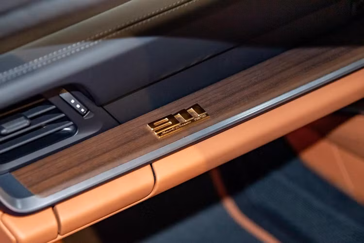 Bên trong khoang lái xe thể thao giới hạn Porsche 911 Sport Classic 2023 đầu tiên đặt chân đến Singapore được bọc da Cognac cổ điển sáng màu với các họa tiết Houndstooth, bên cạnh đó còn có các chi tiết ốp bằng gỗ Paldao sẫm màu.