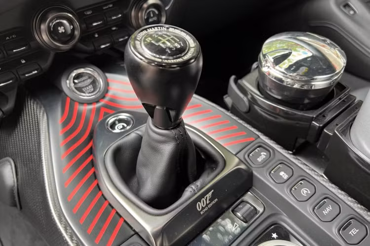 Bảng điều khiển trung tâm có thêm chi tiết những đường vẽ mô phỏng lại chiếc xe Aston Martin V8 Vantage xuất hiện trong bộ phim The Living Daylights vào năm 1987, các sọc màu đỏ, dưới cần số là ký hiệu thể hiện đây chính là Aston Martin Vantage bản 007 Edition. 