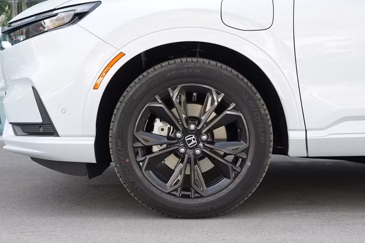 Bên sườn, Honda CR-V e:PHEV 2023 chỉ có thêm một cổng sạc ở chắn bùn trước bên trái và ốp gương ngoại thất màu đen. Xe dùng vành hợp kim 19 inch với thiết kế 5 chấu như bông hoa tương tự bản thường.