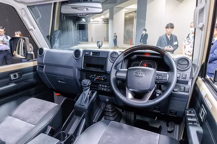 Tại thị trường Nhật Bản, Toyota Land Cruiser 70 Series 2024 có trang bị tiện nghi khá cơ bản như điều hòa chỉnh tay, cổng USB Type C, cửa sổ chỉnh điện, phanh tay chỉnh cơ và khóa cửa trung tâm. Trong khi đó, màn hình cảm ứng trung tâm không phải là trang bị tiêu chuẩn của xe.