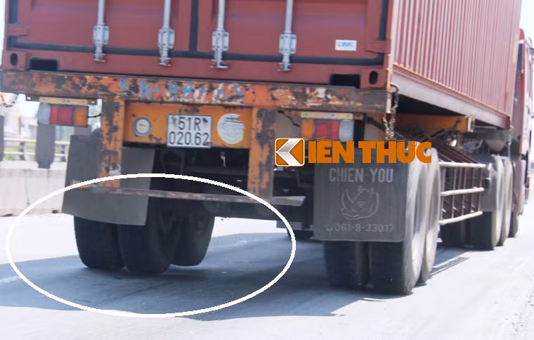 Thùng container nghiêng hẳn một bên vì bánh sau xe đầu kéo chạy qua lớp nhựa đường trồi cao hàng chục cm...