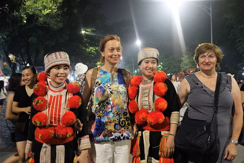 Du khách nước ngoài hào hứng chụp ảnh cùng các cô gái người Dao xinh đẹp.