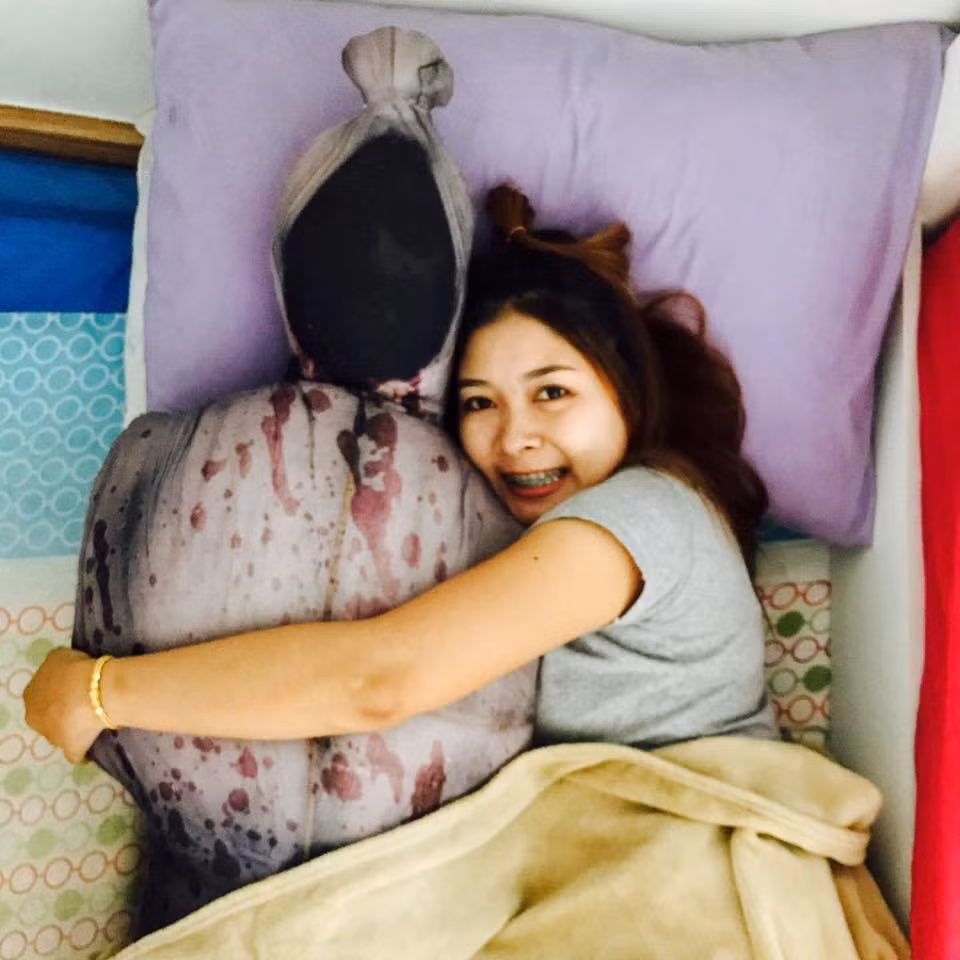 Chiếc gối ôm này mô phỏng hình pocong - tấm vải niệm quanh xác người chết. Theo quan niệm dân gian của Indonesia, trước khi chôn người chết, người ta sẽ quấn quanh cái xác bằng vải trắng từ đầu đến chân, sau đó sẽ được buộc bằng dây thừng ở 3 điểm: ở trên đỉnh đầu, quanh cổ và ở dưới chân. Khi linh hồn người chết còn vương vấn trần gian, không siêu thoát, họ sẽ trở về dưới hình dạng pocong - không mặt mũi, với bộ dạng đáng sợ.