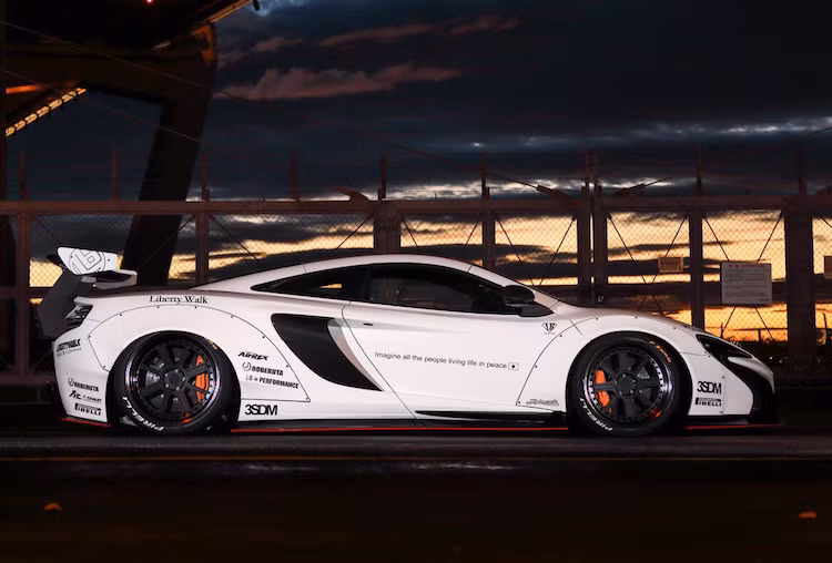 Theo đúng phong cách Liberty Walk, cả 4 vòm bánh xe của McLaren 650S đã được nới rộng bằng các tấm ốp được khoan lỗ bắt vít vào thân xe. Để vừa với hốc bánh lớn hơn, bộ mâm Rotiform thiết kế nhiều nan với lòng cực rộng đã được hãng độ này lựa chọn.