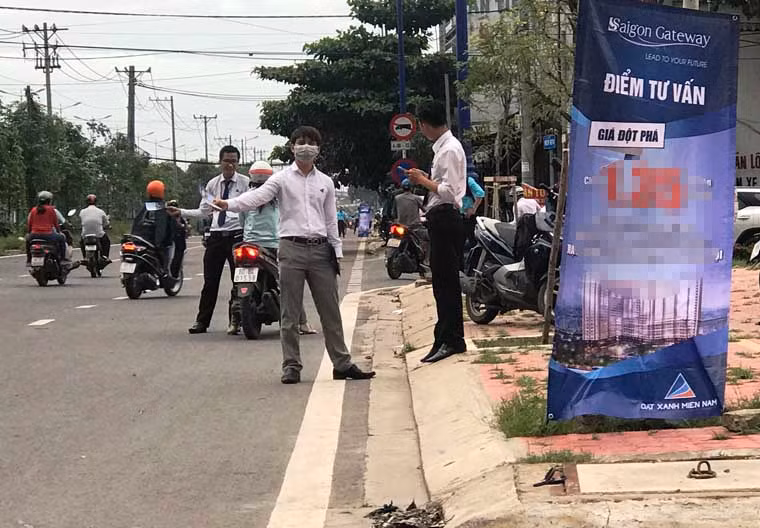 Những người làm công việc tiếp thị này tràn xuống lòng đường, chiếm trọn phần đường giành cho xe máy...