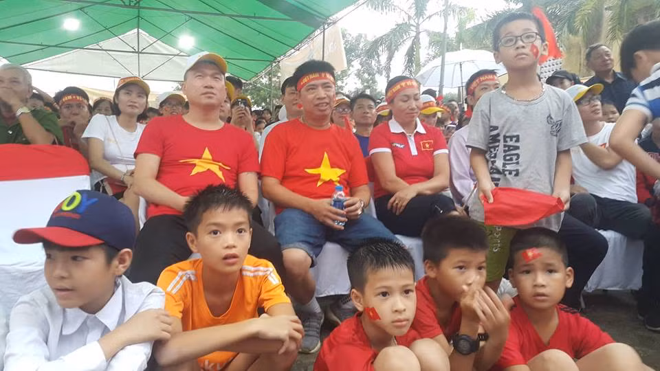 Bố Văn Toàn (áo cờ ngồi giữa) chú ý theo dõi trận đấu.