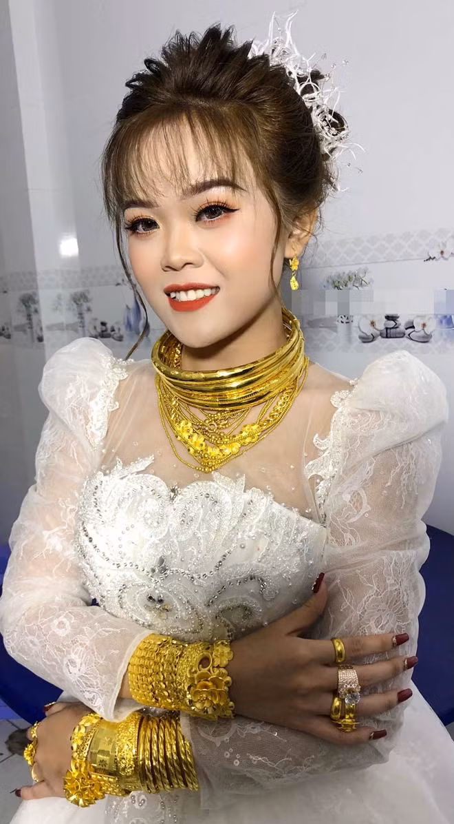 Tháng 6/2021, cô dâu 18 tuổi Nguyễn Thị Trúc Mai (quê Bạc Liêu) trở thành tâm điểm chú ý của mạng xã hội khi đeo vàng kín cổ, tay và ngón tay trong ngày cưới. Ảnh: Dân Việt