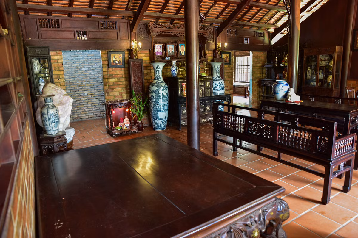 Căn nhà được dựng từ 54 cột gỗ gõ mật. Gian chính rộng 60m2, với đầy đủ nội thất đặc trưng như bộ trường kỷ, phản, bộ bàn ghế ăn cơm, án thờ....Ảnh: Dân Việt