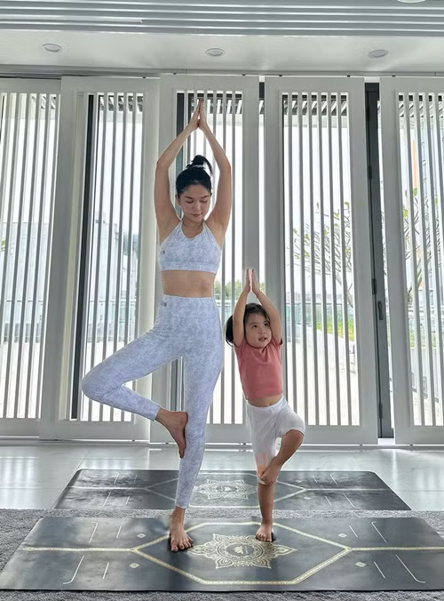 Nữ người mẫu cùng bé He tập yoga.
