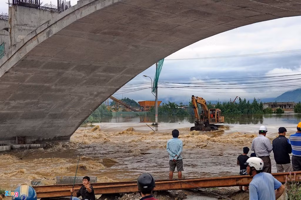Nơi đây có một cây cầu nhỏ người dân vẫn thường đi lại hàng ngày đã bị chìm trong nước chảy xiết. Khoảng 16h chiều 13/12, bốn người đàn ông liều lĩnh lội bộ băng qua khu vực này và bị kẹt giữa dòng nước cuồn cuộn. Lực lượng công an khu vực và một xe máy xúc đang thi công gần đó đã lao ra trong dòng nước xiết để cứu.