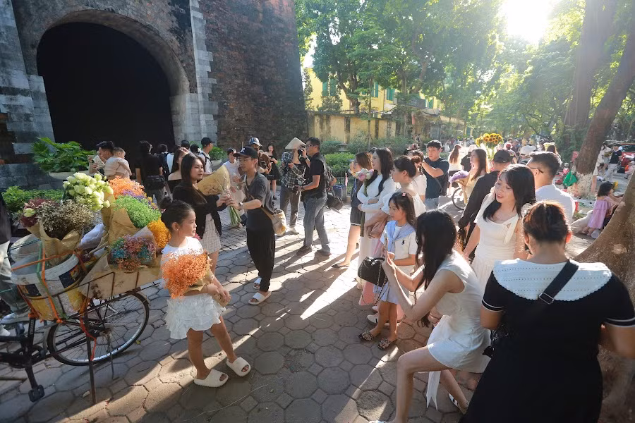 Thế nhưng do số lượng người quá đông, rất nhiều người mua hoa xong phải đứng chờ để đến lượt mình chụp với xe hoa.