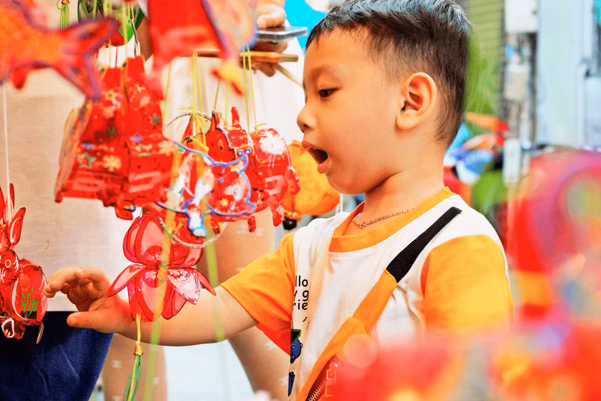 Các em nhỏ xúng xính váy áo được ba mẹ dắt đến để tự tay lựa chọn những chiếc lồng đèn ưng ý.