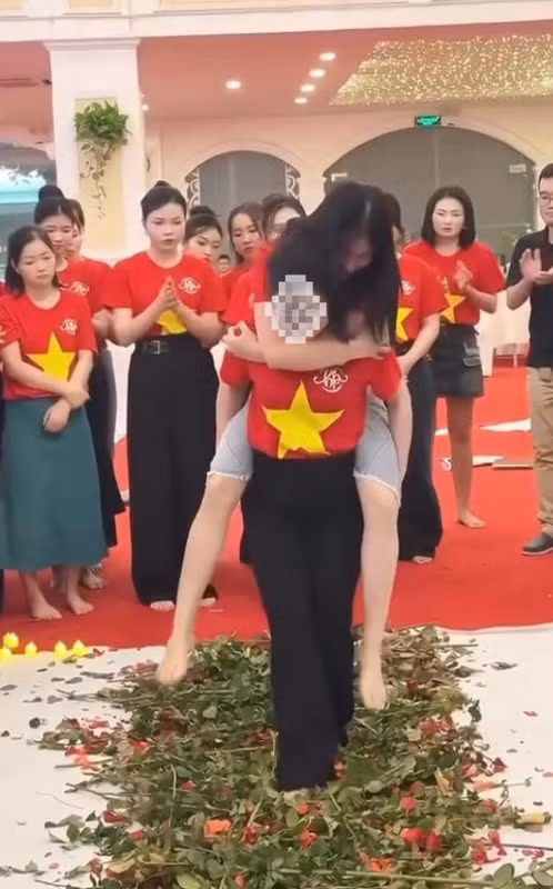 Theo đó, trò chơi này có cách thức khá kì lạ, khi một người cõng đồng nghiệp trên lưng, đi chân trần giẫm lên một đoạn đường trải hoa hồng.