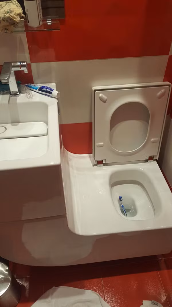 Thiết kế bồn rửa mặt với bồn cầu cạnh nhau rồi còn nối 1 “chiếc cầu trượt” bóng láng thế kia? Báo hại lại phải thay bàn chải!