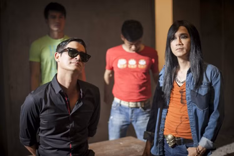 Năm 2015, Minh Thuận xuất hiện trên màn ảnh rộng với vai diễn đại gia giang hồ trong “Quý tử bất đắc dĩ”. Là người chỉn chu trong công việc, Minh Thuận đã tạo hình tượng cho nhân vật này. Anh tô mắt đen, diện quần áo với phụ kiện rườm rà và để mái tóc dài mượt. (Ảnh: Zing) 