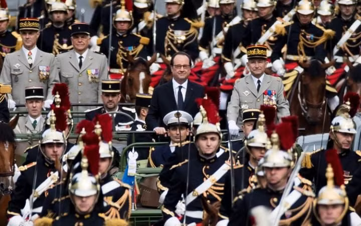 Tổng thống Francois Hollande được hộ tống bằng xe Jeep và các binh sĩ chuẩn bị tiến vào lễ đài.