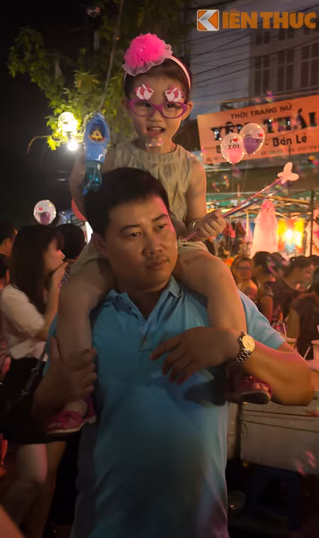 Để các cháu nhỏ không bị chèn ép trong cảnh phố đông người và có thể ngắm nghía xung quanh, nhiều vị phụ huynh chọn cách kềnh con lên cổ.