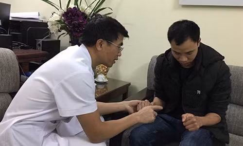 PGS.TS Lê Văn Đoàn đang khám cho một bệnh nhân gặp chấn thương tay. Ảnh: Hà Quyên.