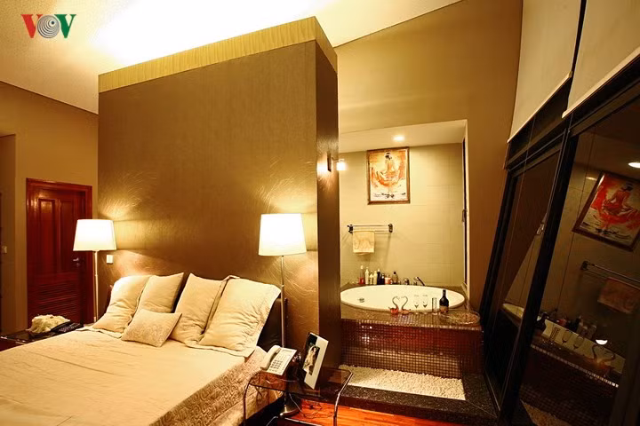 Phòng tắm nằm ngay trong phòng ngủ, không có ngăn cách và thoáng cả về bên ngoài qua vách kính lớn.