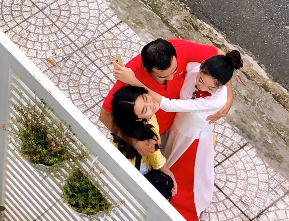 Đi kèm với những khoảnh khắc bố con MC Quyền Linh không ngại thể hiện tình cảm ôm, hôn ngay trước cổng nhà, chị Dạ Thảo viết: "Sáng nay, trước khi ba Linh đưa hai em đến trường, mẹ Thảo đang cắt tỉa cây trên sân thượng mà phải tạm ngưng để lưu lại những khoảnh khắc này...".