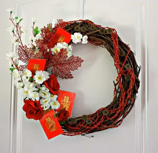 Một vòng hoa với cách trang trí đúng chất phương Đông, lì xì và đồng xu, giúp ngôi nhà như có tài lộc gõ cửa vào dịp đầu năm mới.