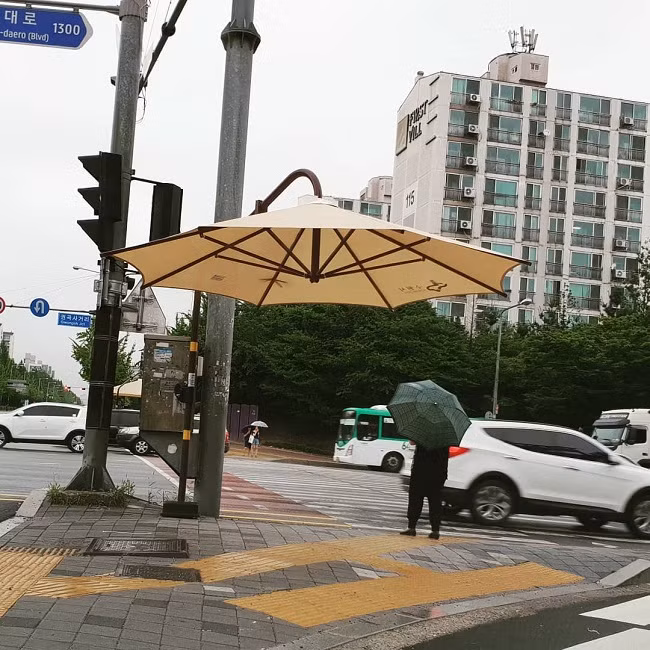 Một chiếc ô được dựng lên dành riêng cho mọi người đang đứng chờ đèn đỏ khi trời mưa.