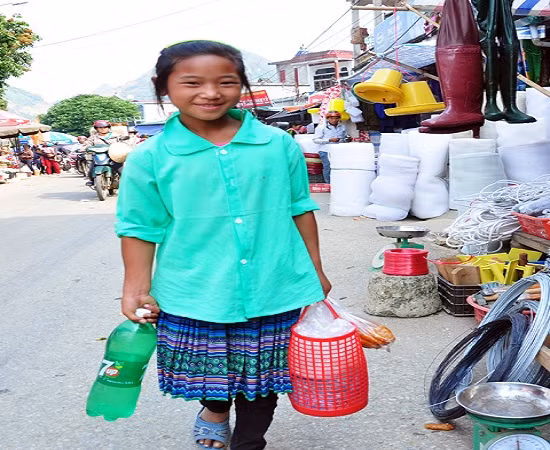 Em bé vùng cao thay bố mẹ xuống chợ mua các nhu yếu phẩm cần thiết phục vụ gia đình.