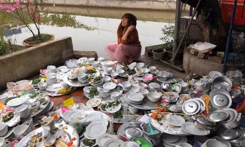 Bức ảnh cô gái ngồi cạnh 'núi' bát đĩa bẩn.