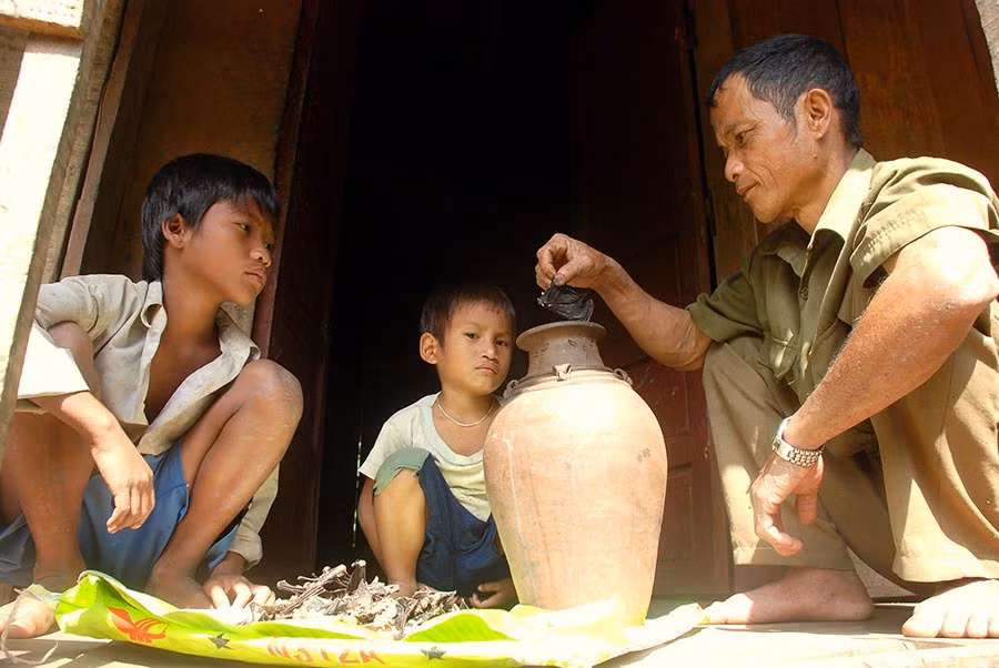 Sau khi thui xong, thịt con dơi sẽ được dân làng săn dơi Nước Chạch trộn với cơm nóng cùng với muối bỏ vào ché làm mắm. Ảnh: Trường Đăng.