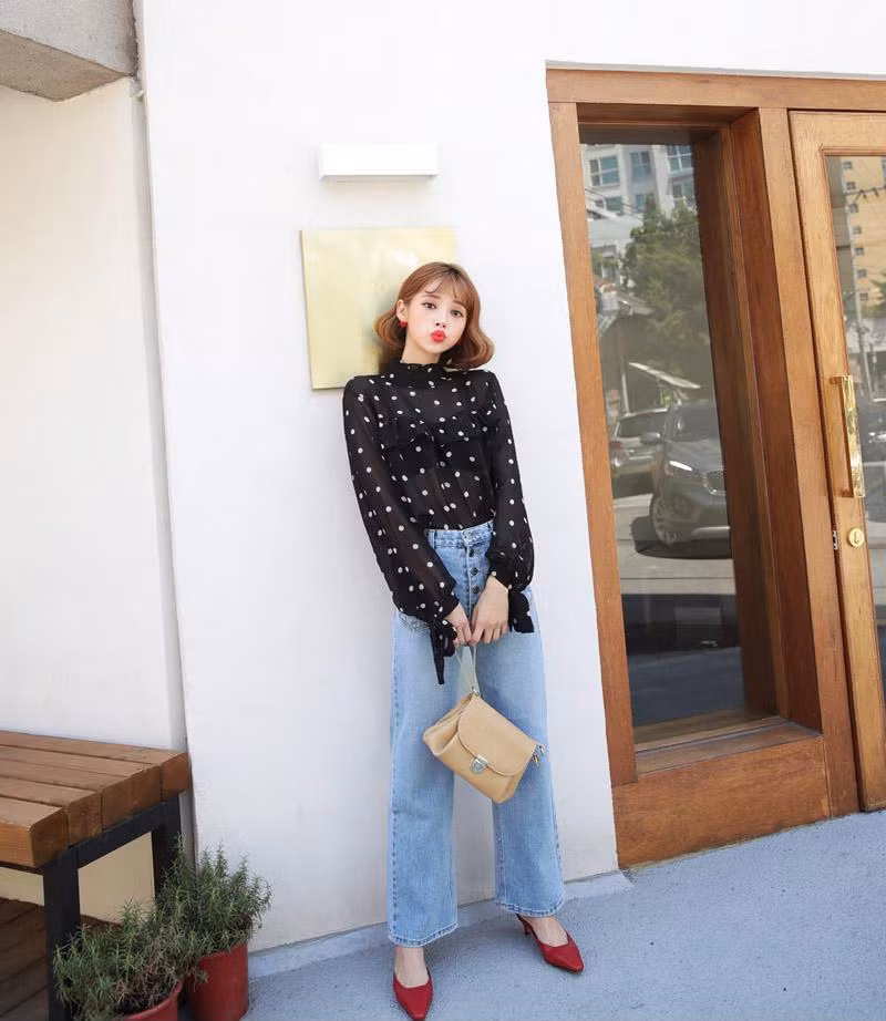 Chọn một chiếc áo chấm bi tay thắt nơ, phối với quần jeans ống suông trong một ngày nắng êm dịu chắc hẳn sẽ khiến nàng thôi thúc mọi ánh nhìn khi bước xuống phố.