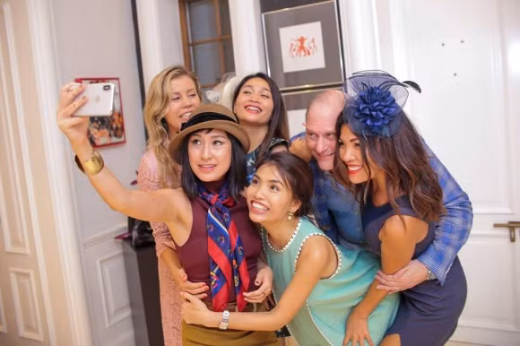 Kathy Uyên cầm máy ảnh selfie cùng bạn bè trong tiệc sinh nhật.