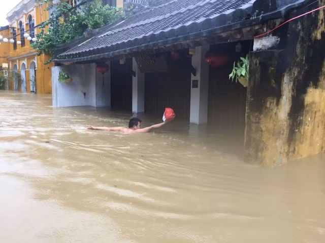 Người dân nếu không có thuyền thì chỉ còn cách bơi giữa đường phố Hội An. Nguồn ảnh: Tuổi Trẻ