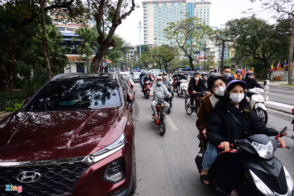 Dưới lòng đường Thanh Niên, phía trước lối vào chùa Trấn Quốc có hàng dài ôtô đỗ của du khách. Giao thông ở đây trở nên lộn xộn và gây ùn tắc khi có ôtô đi qua.