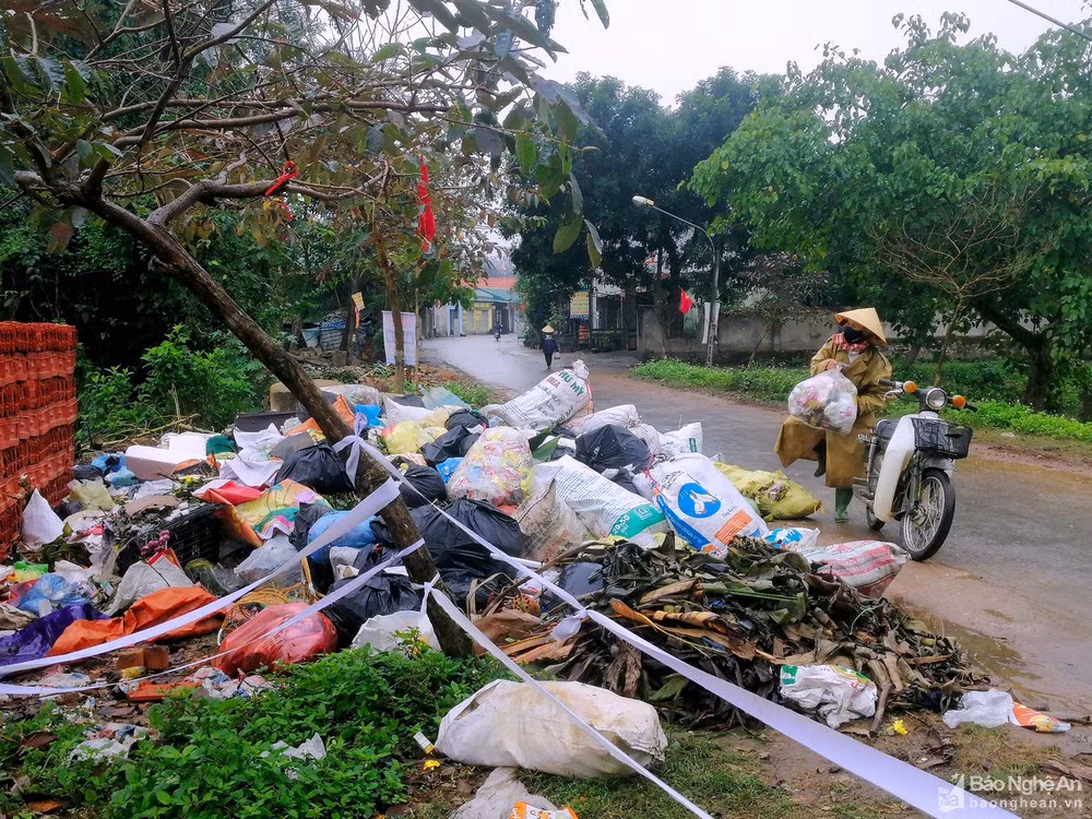 Dọc tuyến Quốc lộ 46 đi qua các huyện Thanh Chương, Nam Đàn, Hưng Nguyên... không khó để nhận thấy những bãi rác khổng lồ xuất hiện sau Tết. Trong ảnh: Người dân xã Thanh Dương, huyện Thanh Chương đưa rác tập kết thành bãi khổng lồ trên tuyến đường làng. Ảnh: Q.A