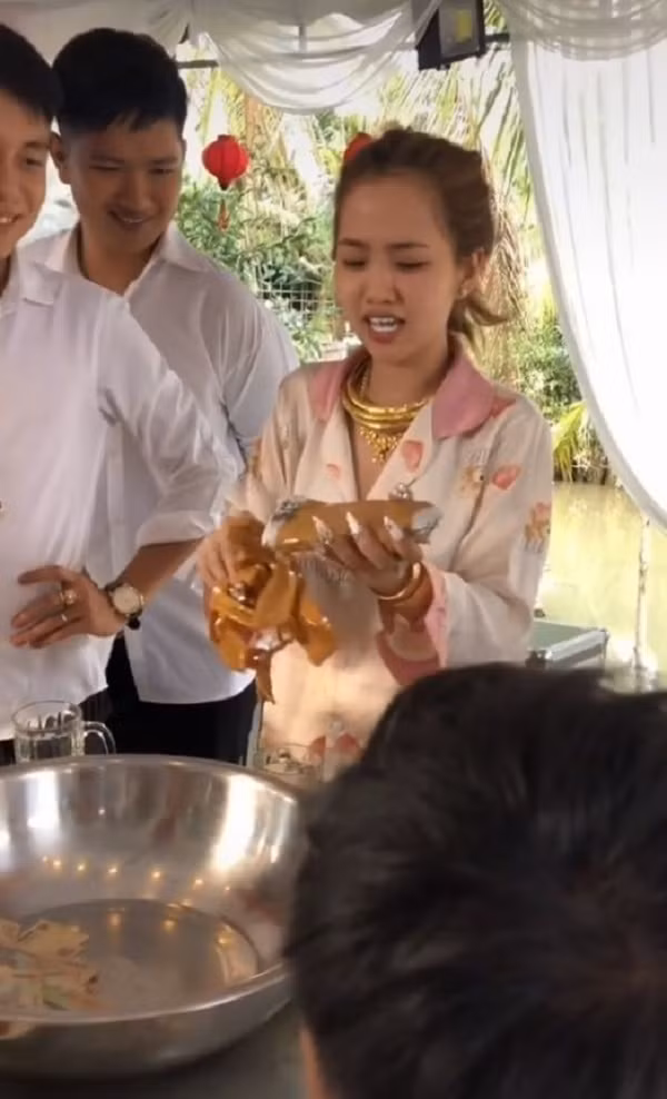 Dù gỡ quà cưới hơi mất công nhưng cô dâu vẫn nở nụ cười tươi rói đủ biết tình cảm của cô dâu và nhóm bạn tốt thế nào. Ảnh: TikTok C.J