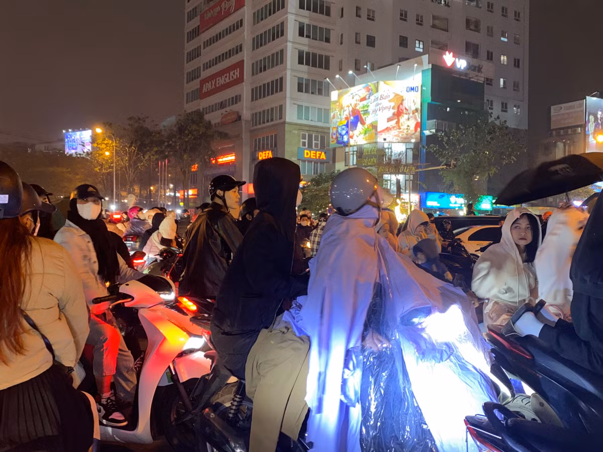 Từ khoảng 19h, thời tiết Hà Nội bắt đầu có mưa phùn kém hơi sương ẩm ướt điều này khiến nhiều người dân phải mặc áo mưa để chờ đón màn trình diễn drone.