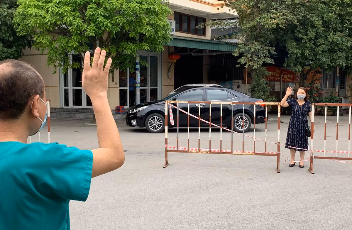 Vì những an toàn trong quy tắc cách ly COVID-19 nên bác sĩ Hùng và vợ đứng cách xa cả chục mét, chỉ có thể vẫy tay chào và nhìn nhau. Cả hai vẫn đeo khẩu trang, nói với nhau những câu ngắn gọn để đối phương yên tâm. "Anh cứ yên tâm điều trị cho bệnh nhân, ngoài này đã có em và các con lo" - Chủ nhân những tấm hình trên thuật lại lời của vợ bác sĩ Hùng.