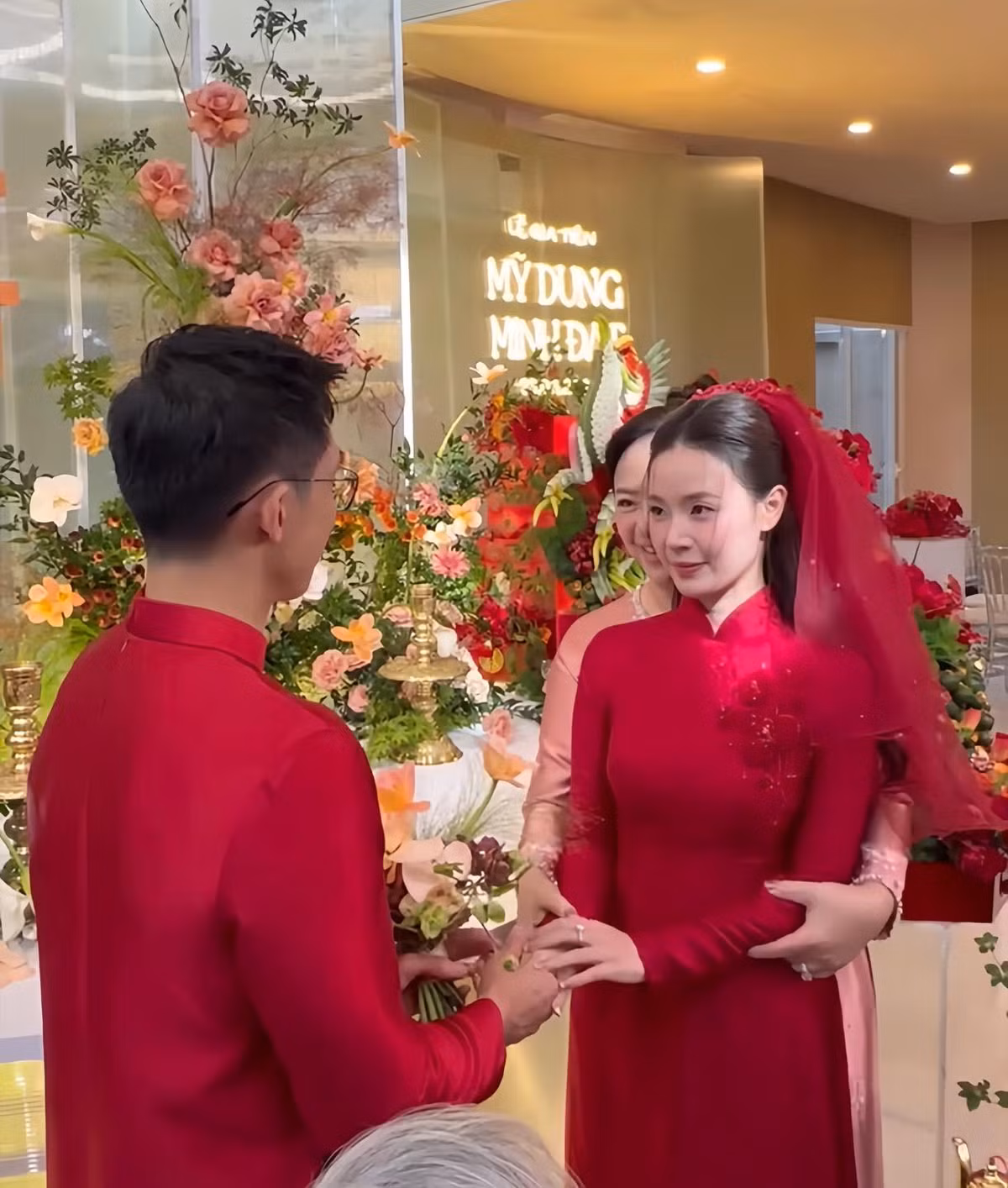 Cặp đôi chọn áo dài đỏ thiết kế riêng, có hoạ tiết hoa mơ của NTK Dũng Nguyễn.
