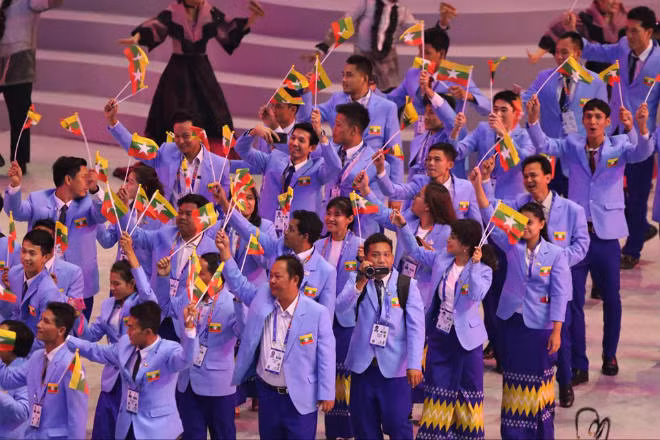 Đoàn thể thao Myanmar với trang phục vest xanh và chân váy truyền thống.