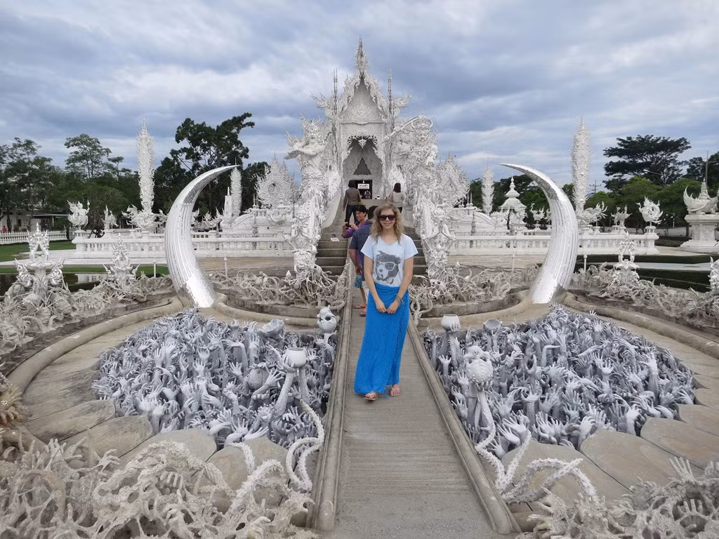 Sở hữu nhiều nét độc đáo và huyền bí, kiến trúc của đền Wat Rong Khun còn mang nhiều ý nghĩa sâu xa về sự luân hồi. Biểu trưng cho "cõi cực lạc", gian chính của ngôi đền được nối bởi một cây cầu bắc qua hồ nước nhỏ với hàng trăm bàn tay vươn ra. Những bàn tay đại diện cho quan niệm "tham sân si" luôn níu kéo con người đến với bến bờ hạnh phúc. Ảnh: Kiran and Maddie.
