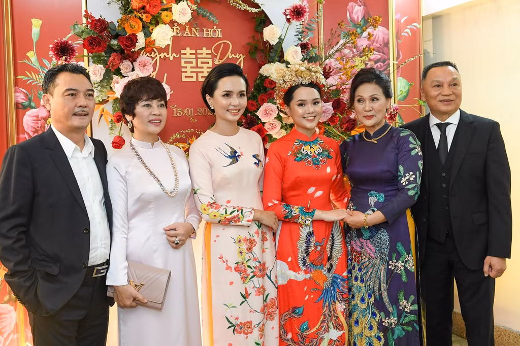 Trong khi cô dâu cực kỳ nổi bật thì mẹ và chị gái cô lại ăn mặc, trang điểm khá nền nã. Mẹ Quỳnh Anh diện trang phục áo dài tối màu in hình công phượng, dù là phu nhân nhưng bà không đeo quá nhiều trang sức trong đám hỏi của con gái.