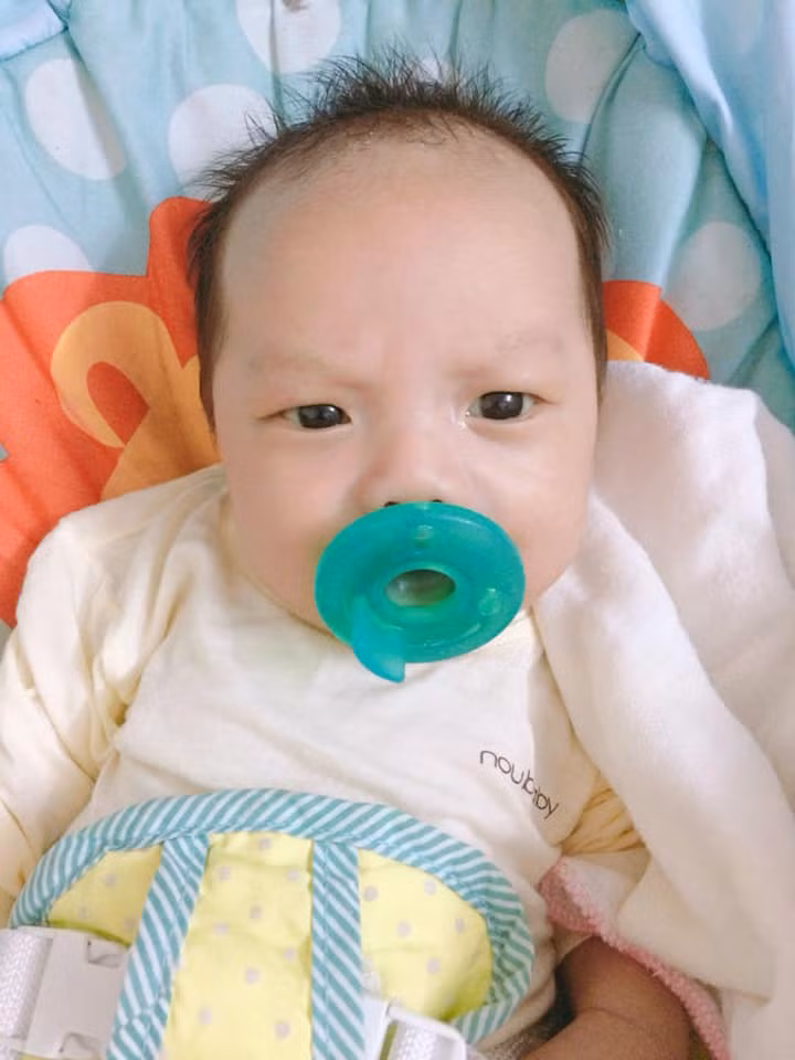 Cậu bé nhăn trán ngay cả khi ngậm ti giả...