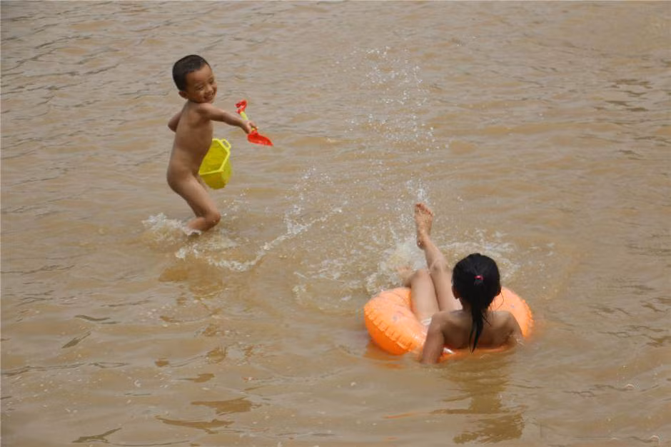Các cháu mang phao và đồ chơi tận hưởng "món quà" được bơi lội ngay giữa lòng thành phố.