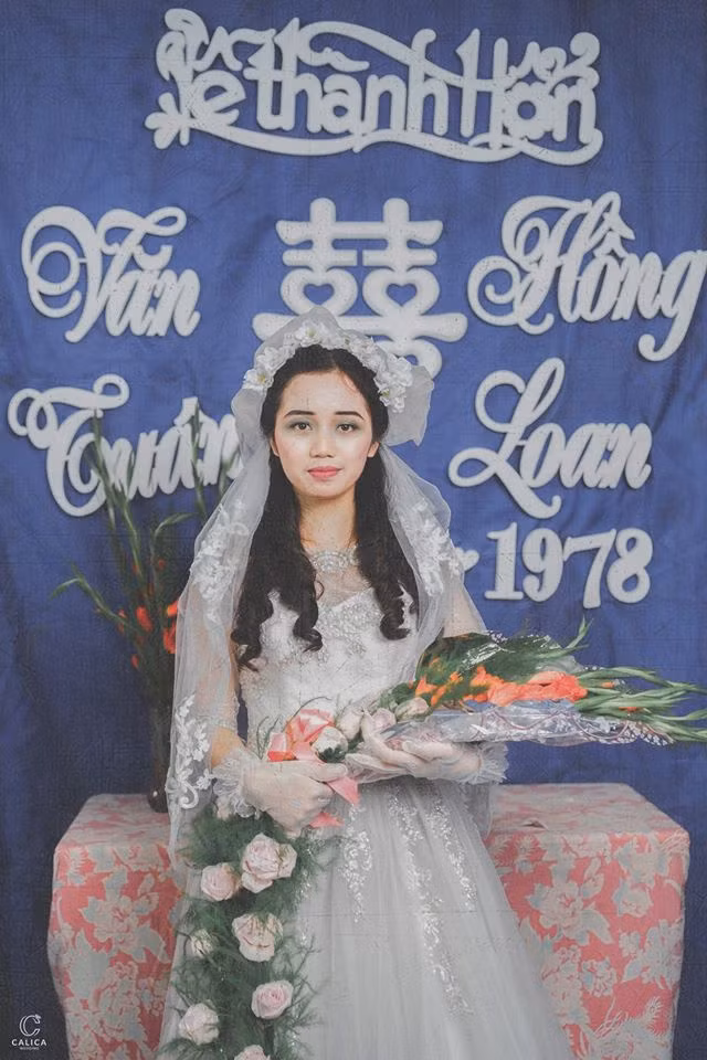 Bộ váy của cô dâu diêm dúa, nhiều hoa văn, trông cực rối mắt nhưng không hề dễ tìm. Hiện tại, các mẫu váy cưới này gần như không còn, chính bởi thế mà nhiều dân mạng đặt ra nghi vấn rằng có lẽ ê kip chụp ảnh cưới đã phải đặt may riêng.