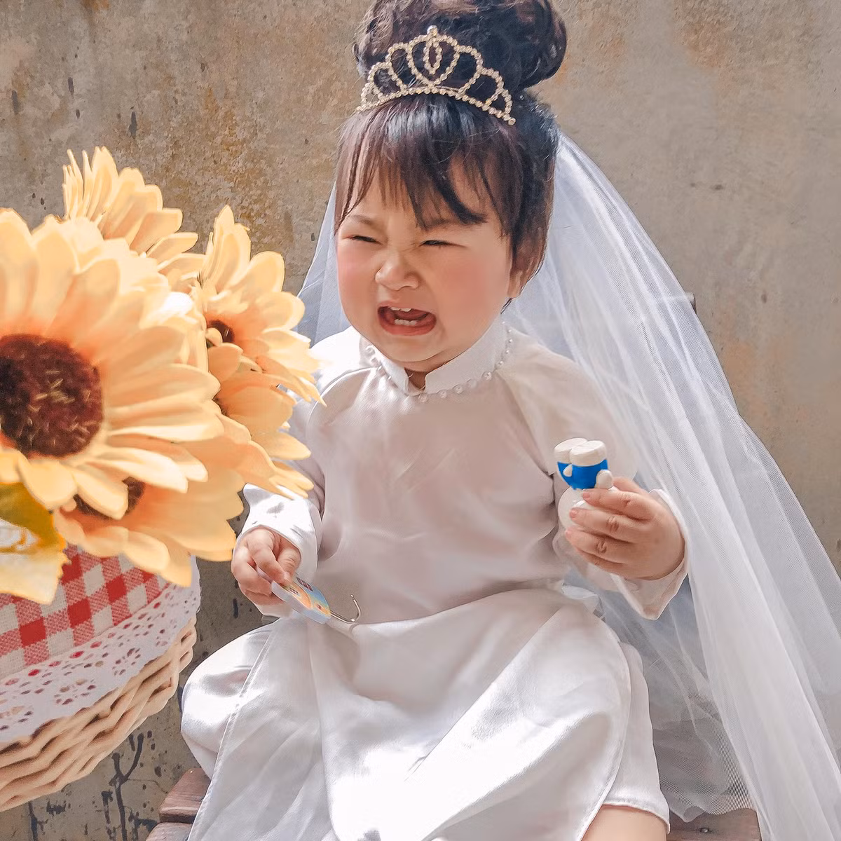 Biểu cảm cực đáng yêu của em bé khiến ai nấy đều phải tan chảy. Cô dâu gì mà còn khóc nhè đòi mẹ thế này. Chiếc má bánh bao ửng hồng, phúng phính của "cô dâu" càng khiến dân tình chao đảo.