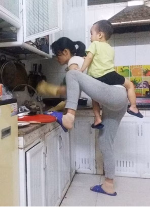 Hình ảnh người mẹ phải vừa rửa bát, nấu cơm, vừa trông con nhỏ vì quấy khóc xuất hiện trên mạng xã hội khiến ai nấy đều rớt nước mắt.