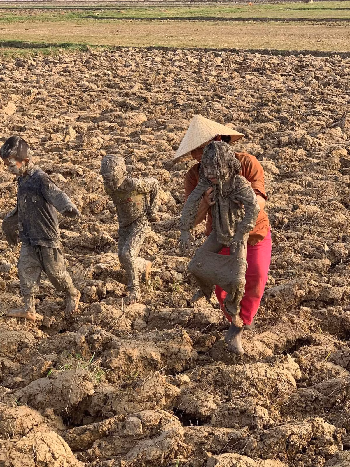 Trong lúc người bà phải lội ruộng để đưa cháu lên thì một người đứng trên bờ đã chụp lại những hình ảnh này. Loạt ảnh được chia sẻ trên một hội nhóm của những ông bố bà mẹ khiến ai nấy nhịn không nổi cười.