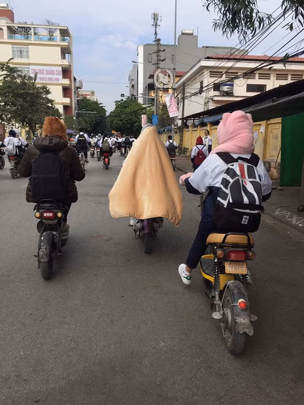 Với chiếc áo khoác đồng phục mỏng dính thì vài ba cái áo len bên trong cũng không ấm thêm được là bao, giải pháp duy nhất chính là...quấn luôn cả chăn đi học mà thôi.